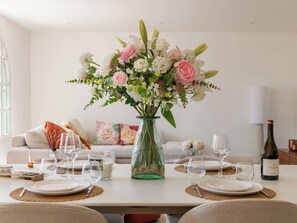A dining table set with plates, glasses, and a vase of flowers. - 155m² Villa – Sea View & Swimming Pool (Vallauris)