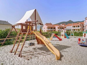Ein Strandspielplatz mit Rutschen und Klettergerüsten.