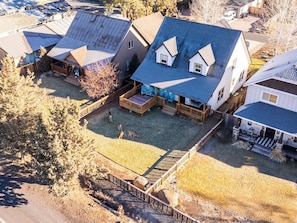 A residential area with multiple houses, a fenced yard, and a small building with a porch.
