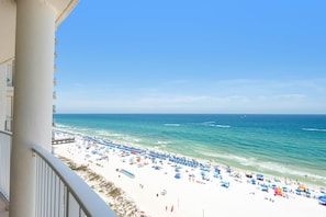 A beach with umbrellas and people, a clear sky, and the ocean. - Free beach chairs!!! LONG BEACH one bedroom!! Great views! (Panama City Beach)