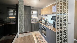 Eine moderne Küche mit Einbauherd, Mikrowelle und Kühlschrank.