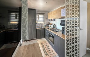 Eine moderne Küche mit Einbauherd, Mikrowelle und Kühlschrank.