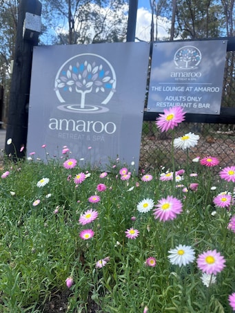 A sign for Amaroo Retreat & Spa with a logo and text indicating it is an adults-only restaurant and bar.. Amaroo Retreat & Spa