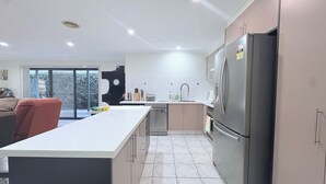 Una cocina moderna con una isla grande, electrodomésticos de acero inoxidable y vistas al exterior.