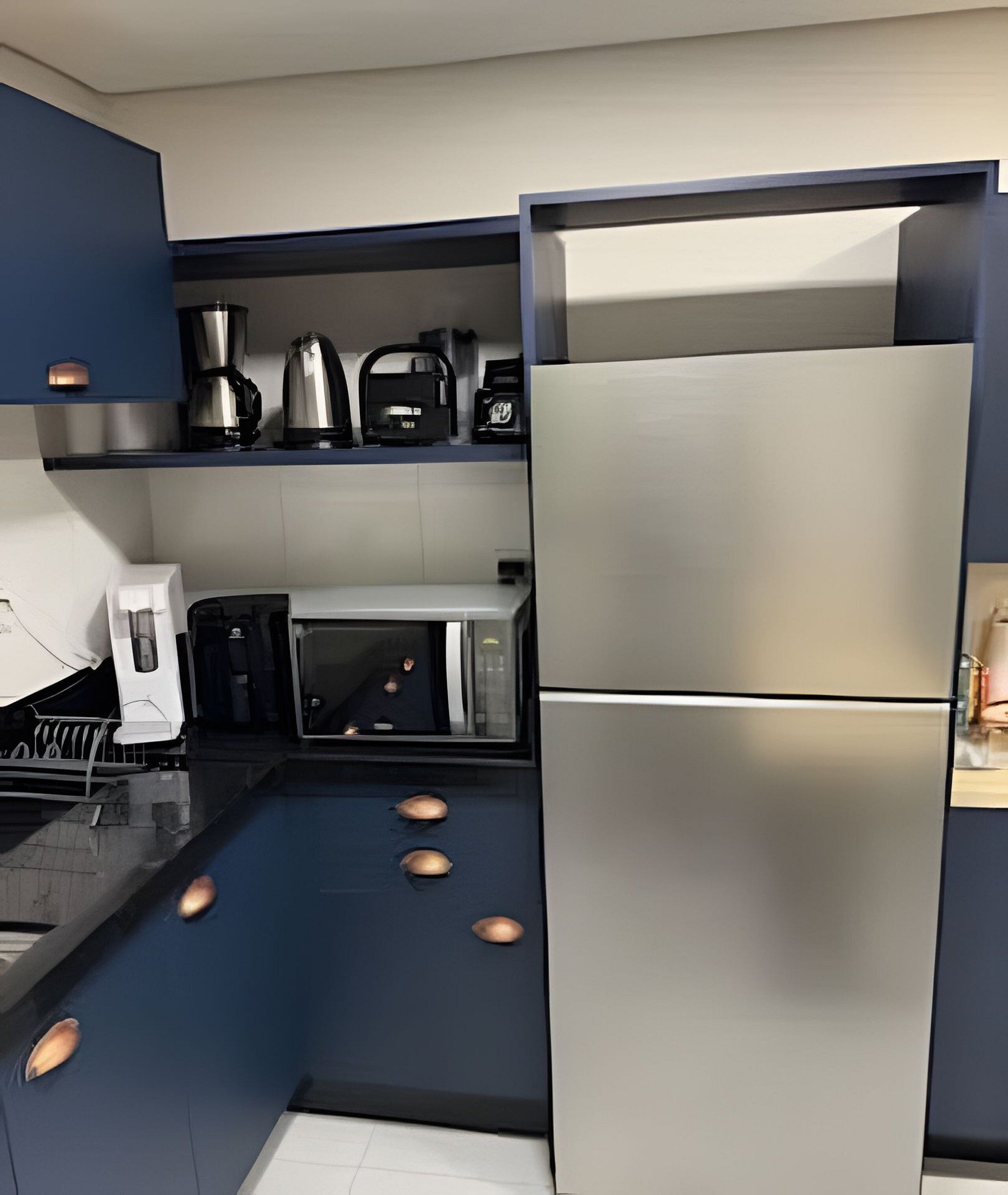A modern kitchen with a stainless steel refrigerator, a microwave, and a coffee maker on the countertop.