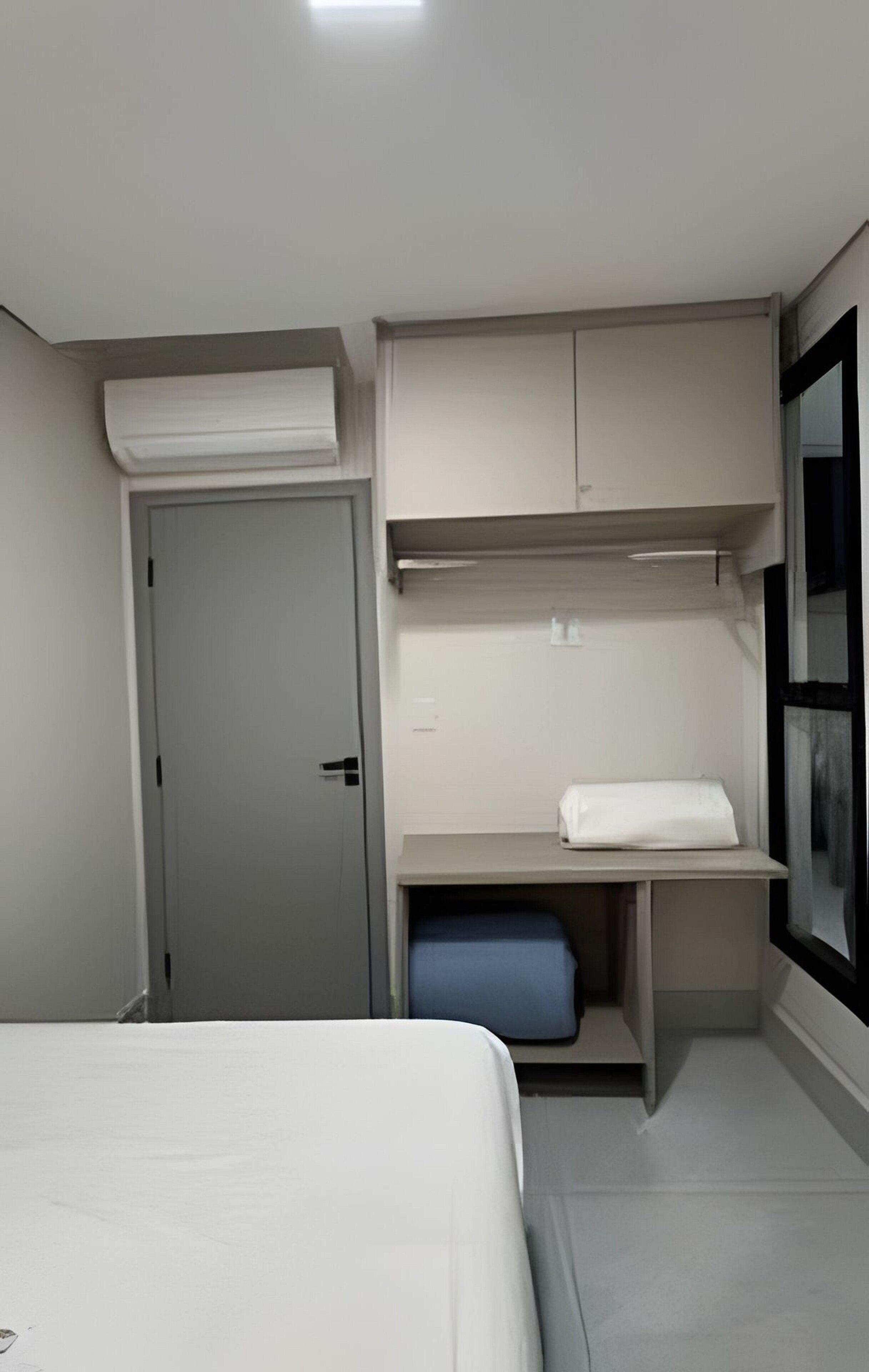 A bedroom with a bed, a wardrobe, and a window.