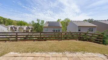 A residential area with houses, a wooden fence, and a paved walkway.
