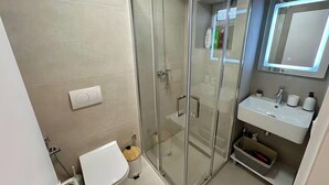 A bathroom with a glass shower enclosure, a white sink, and a mirror above the sink. - Dajti National Park House, Sleeps 7 with AirCon (Tirane)