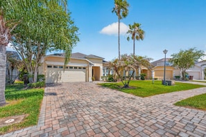 A residential neighborhood with houses, paved driveways, and palm trees. - Poolside Heaven in Cumbrian Lakes (Kissimmee)
