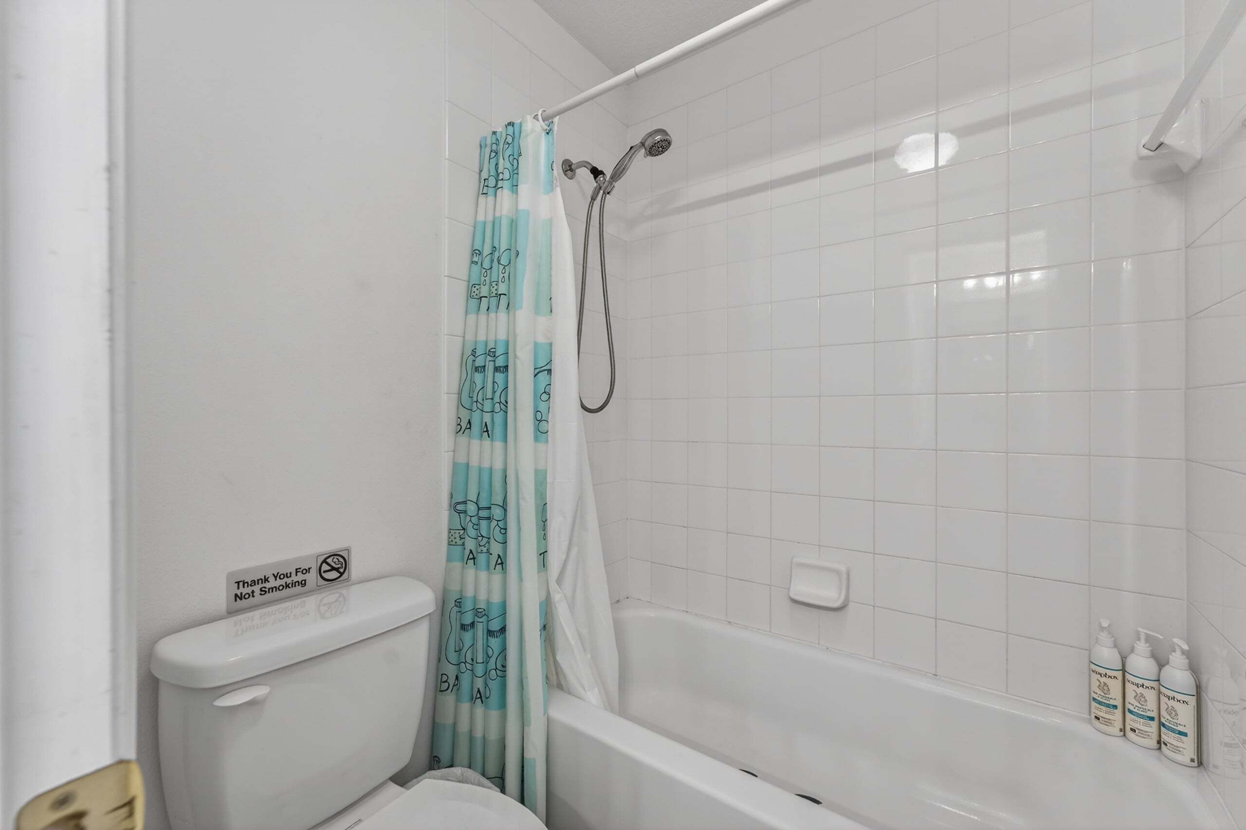 A bathroom with a shower, toilet, and bathtub.