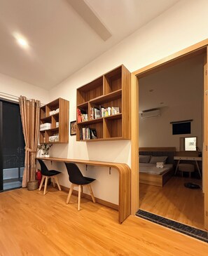 A modern room with a wooden desk, two black chairs, a bookshelf, and a bed. - The Warm Corner, Private 3BR Home in Da Nang (Đà Nẵng)