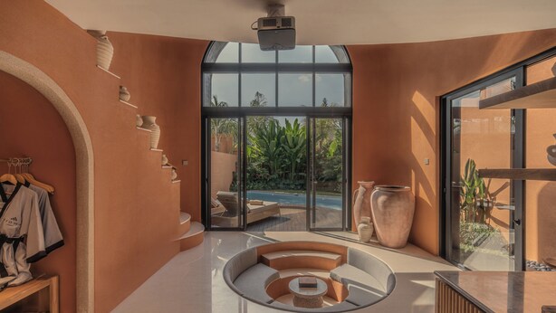 A modern interior with a circular seating area, a large window with a view of greenery, and a wall-mounted shelf with items. - Ajowa Resort & Spa Seminyak by Ini Vie Hospitality (Keroboken Kelod)