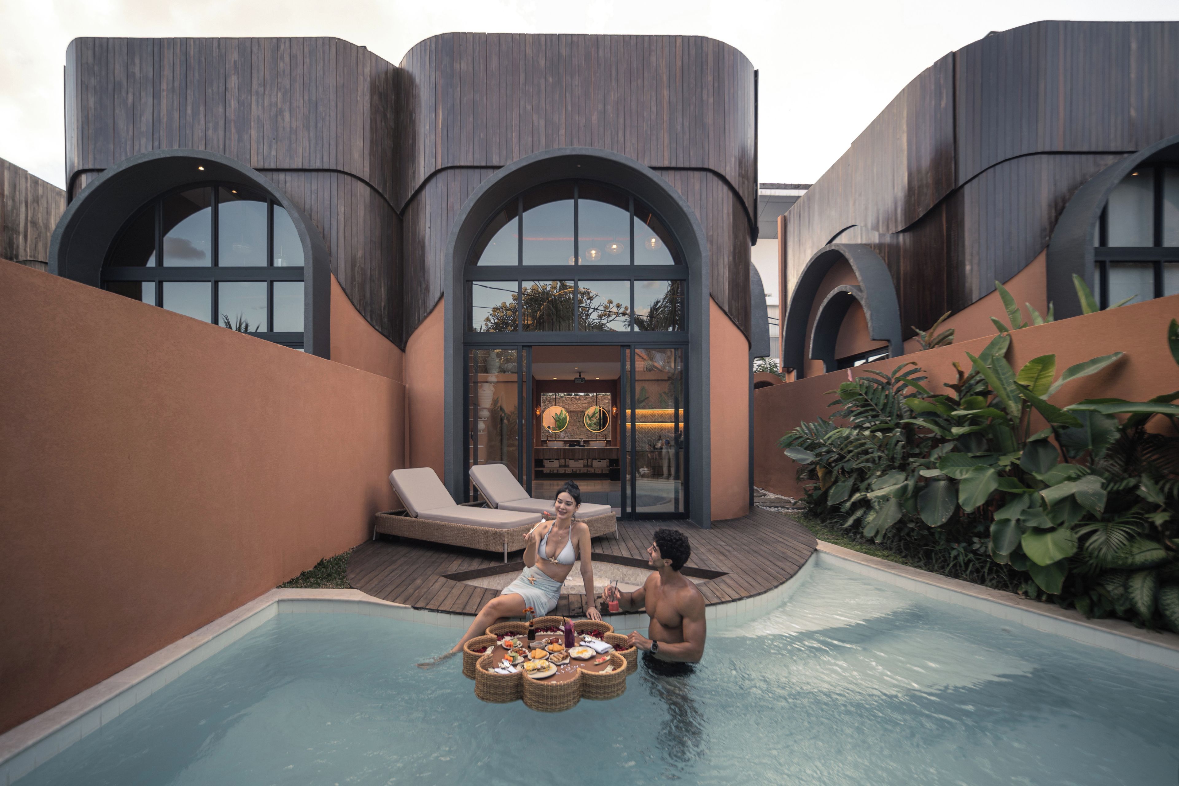 A poolside area with a dining setup and lounge chairs.