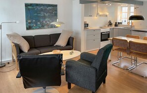A modern living room with a sofa, chairs, a coffee table, and a painting on the wall. - Cozy home in Rudkøbing with WiFi (Rudkøbing)