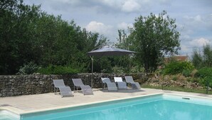 Una piscina con sillas de descanso y una sombrilla.