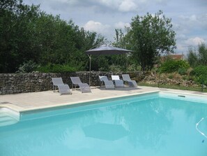 Ein Pool mit Liegestühlen und Sonnenschirm.
