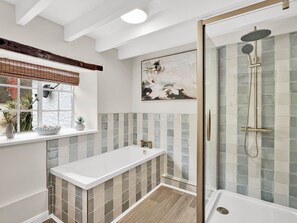 Casa de banho moderna com chuveiro, janela com vista e design minimalista.