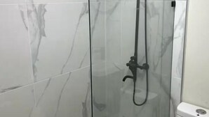 Eine begehbare Duschkabine mit Handdusche und Regendusche.