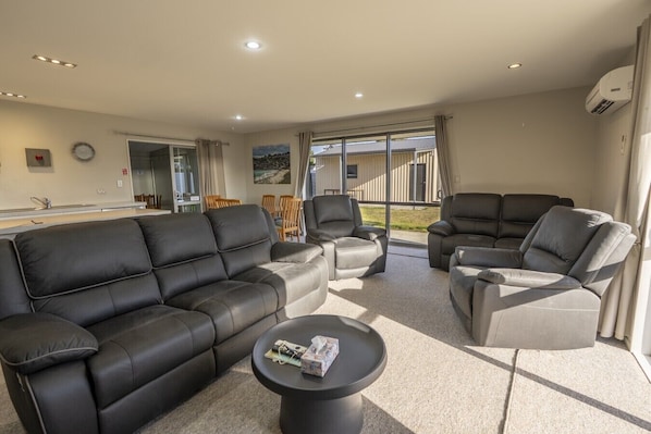 A modern living room with a sofa, armchairs, and a coffee table.