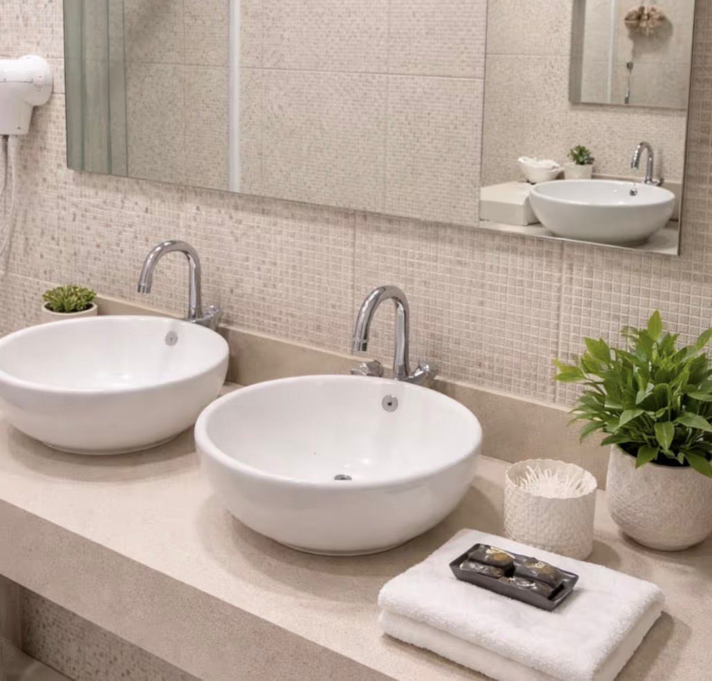 Un baño con dos lavamanos, un espejo y una planta en maceta.