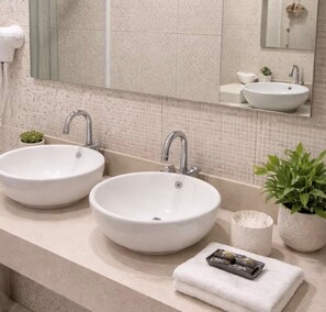 A bathroom with two sinks, a mirror, and a potted plant. - Family Room (Foz do Iguaçu)