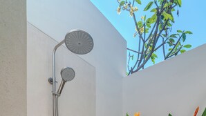A modern shower with a curved design, a wall-mounted control panel, and a small window. - 4BR Villa Vaimala Tropical Home in Seminyak (Badung)