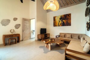 Uma sala de estar com uma mesa de centro de madeira, sofá e televisão.