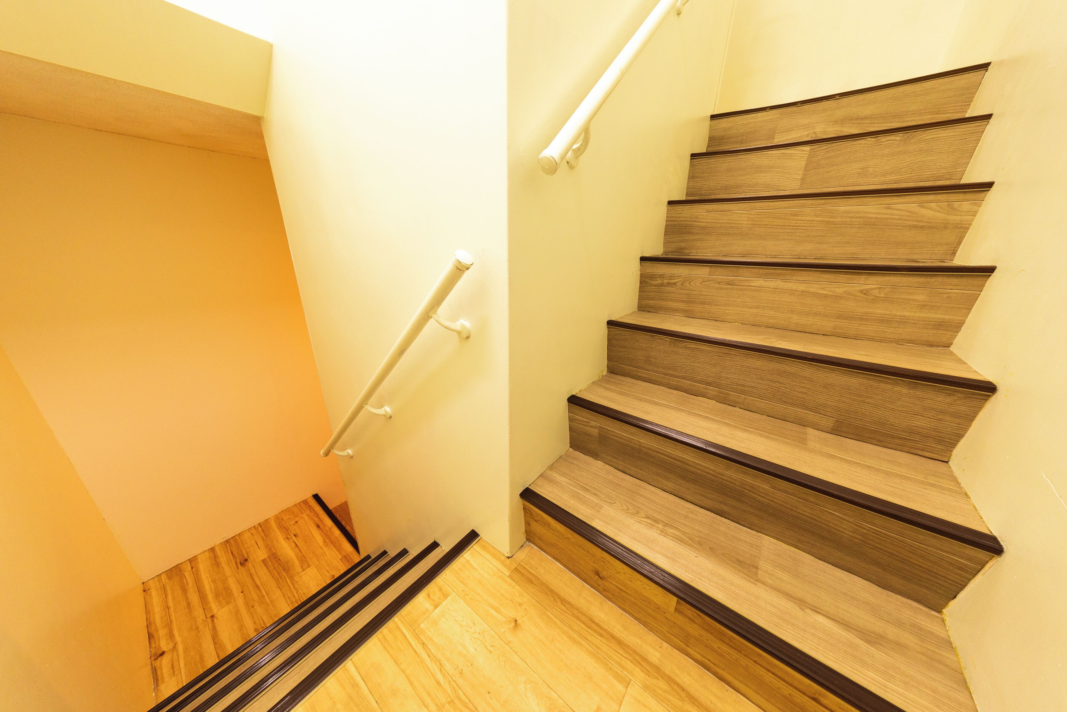 Una escalera de madera con barandilla y piso de madera.