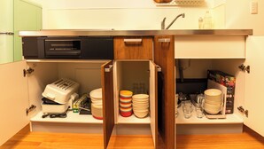 A compact kitchen with a built-in microwave, a toaster, and a sink. - KANDA URBAN SUITES (Chiyodaku Uchikanda)