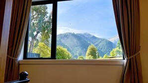 A room with a window overlooking a mountainous landscape. - Queenstown Garden - Lake View (Queenstown)