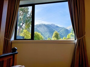 A room with a window overlooking a mountainous landscape. - Queenstown Garden - Lake View (Queenstown)