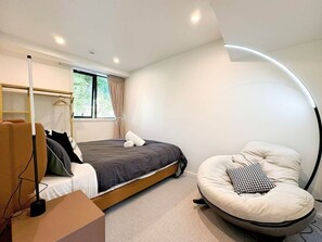 Une chambre à coucher moderne avec un lit, une chaise, un bureau et une fenêtre.