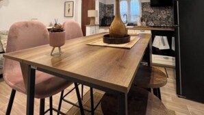 Zona pranzo moderna con tavolo in legno, sedie e un vaso al centro.