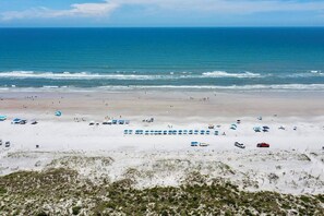 A beach with umbrellas and beach chairs, a sandy shore, and the ocean. - Ocean Cove Retreat, 3-Min Walk to Beach! Perfect for families. (St. Augustine)