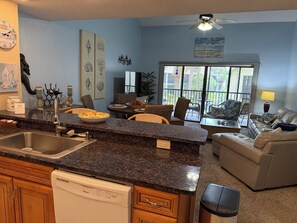 A kitchen with granite countertops, a dishwasher, and a dining area with a table and chairs. - Ocean Cove Retreat, 3-Min Walk to Beach! Perfect for families. (St. Augustine)