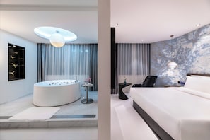Une salle de bain moderne avec une baignoire sur pieds, un miroir rond et un luminaire fixé au plafond.