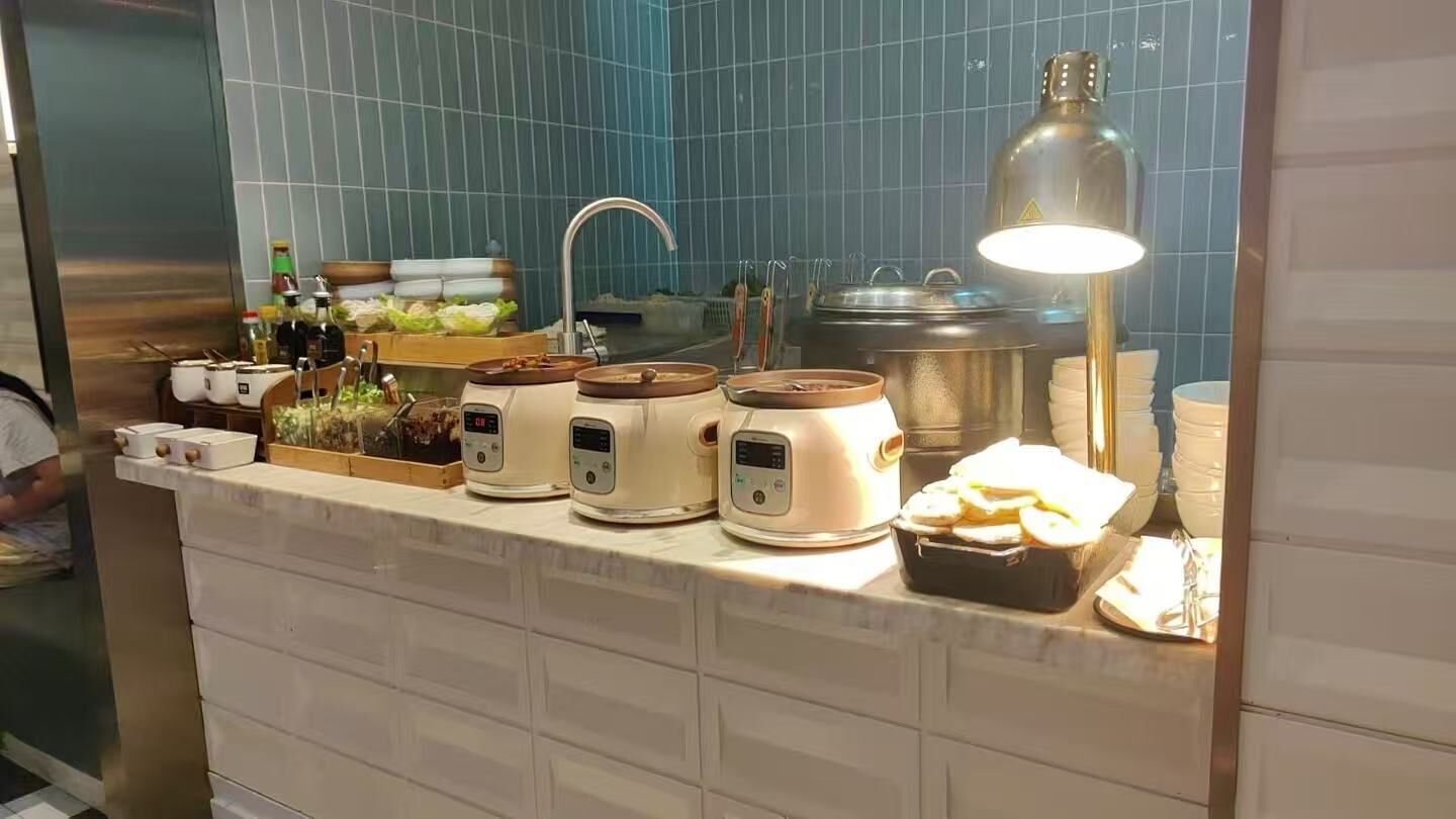 Una encimera de cocina con varios electrodomésticos, un lavamanos y una lámpara.