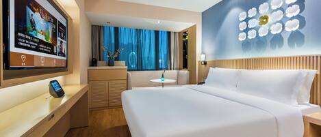 A modern hotel room with a large bed, a TV on the wall, a small table, and a decorative wall piece.