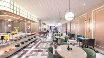 A hotel lobby with a buffet, seating areas, and a check-in desk.