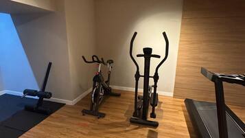 A gym with exercise equipment including a treadmill, stationary bike, and weight machines.