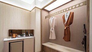 Un baño moderno con tocador, perchero y un banco.