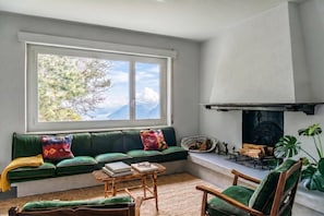 Ein gemütliches Wohnzimmer mit einem grünen Sofa, einem Holztisch und einem Kamin.