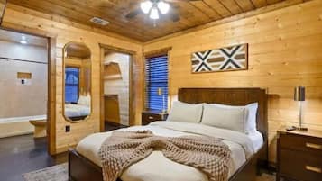 Un dormitorio con paneles de madera, una cama, un ventilador de techo y un espejo montado en la pared.
