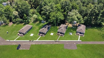 Une vue aérienne d’un quartier résidentiel avec quatre maisons, chacune ayant son propre chemin d’accès et un petit jardin devant.