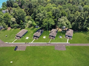 An aerial view of a residential area with four houses, each with a separate driveway and a small front yard.