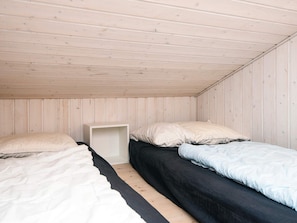 A room with two beds, one with a white bedspread and the other with a black bedspread. - 5 Star Holiday Home in Odder (Odder)