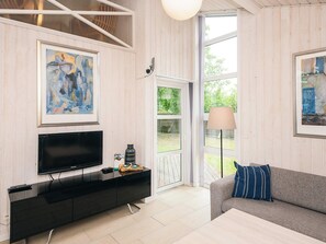 A modern living room with a flat-screen TV, a grey sofa, and two framed artworks. - 5 Star Holiday Home in Odder (Odder)