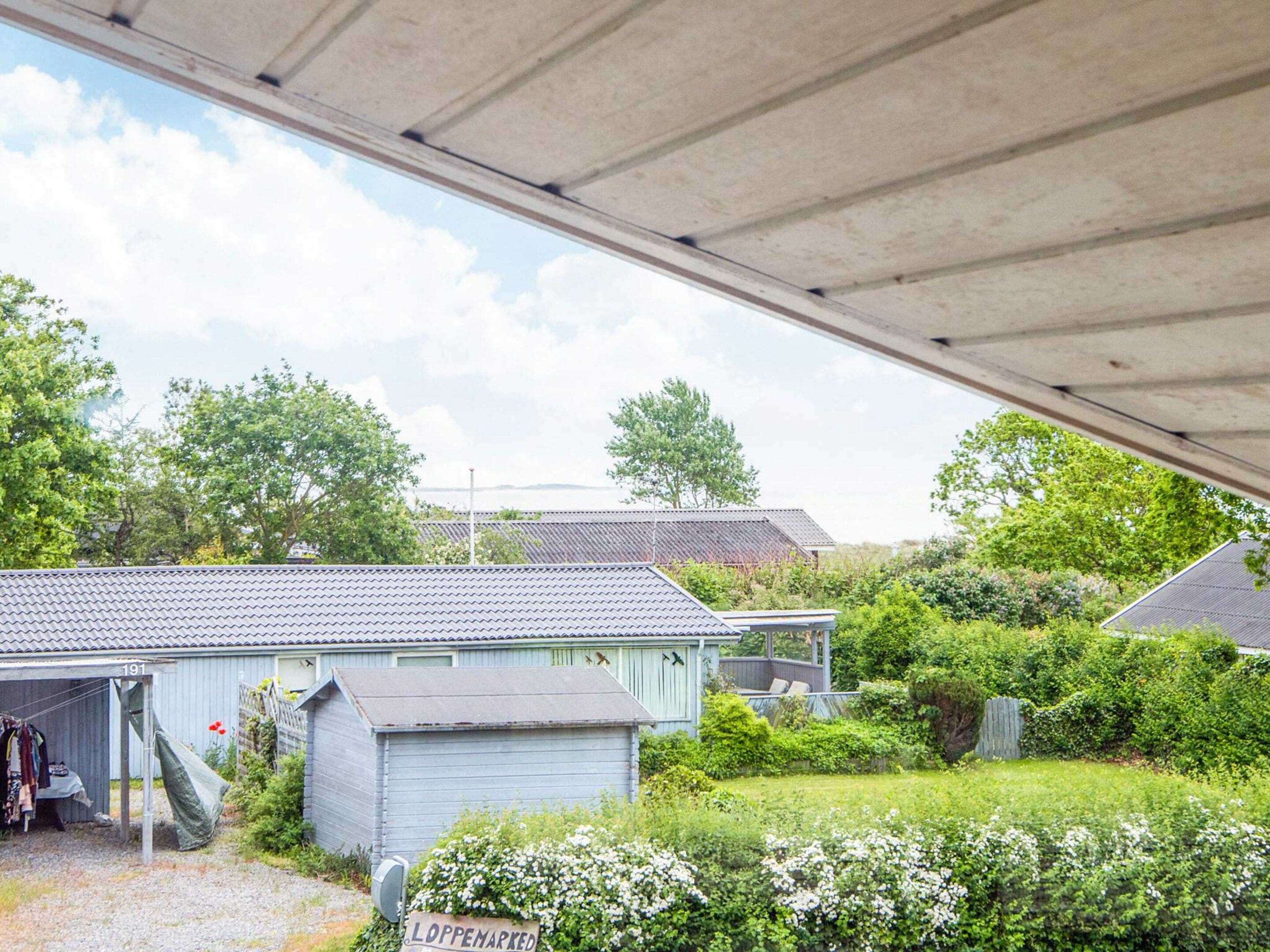 A covered outdoor area with a gravel path leading to a building marked with the number 191.
