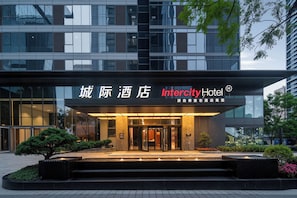 A modern hotel entrance with a glass facade, a signboard with hotel name, and a well-maintained garden area. - IntercityHotel Chongqing jiangbeizui (Chongqing)