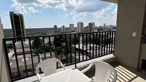A balcony with a view of a cityscape, including high-rise buildings and a distant hill. - Casa Confortavel em Foz do Iguaçu (Foz do Iguaçu)